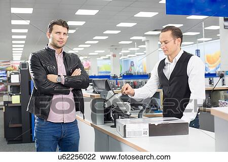 Unsure shopper paying with credit card in electronics store View Large Photo Image Stock Image - Unsure shopper paying with credit card in electronics store. Fotosearch