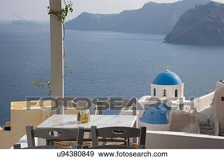 Stock Photo - "View of balcony restaurant and white washed church, Oia, Santorini, Cyclades, Greece". Fotosearch