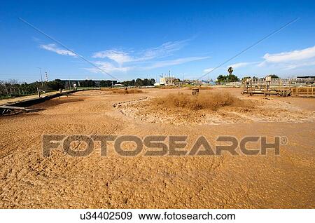 View of brown sludge treatment pool at sewage treatment plant View Large Photo Image Stock Photo - View of brown sludge treatment pool at sewage treatment plant. Fotosearch