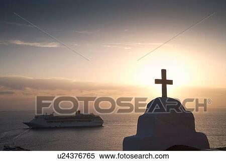 Stock Photography - "View of church and sea ferry at sunset, Oia, Santorini, Cyclades, Greece". Fotosearch