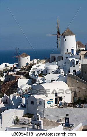 Stock Photo - "View of white washed hillside town and windmill, Oia, Santorini, Cyclades, Greece". Fotosearch