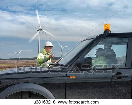 Stock Photo - Windfarm engineers with truck on windfarm. Fotosearch