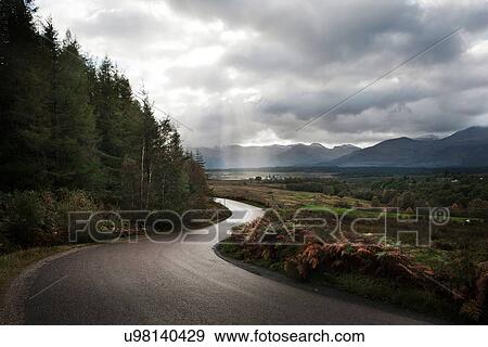 Stock Photo - "Winding road through mountains, Scotland, UK". Fotosearch