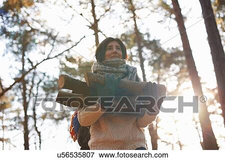 Woman collecting logs for campfire in forest View Large Photo Image Stock Photo - Woman collecting logs for campfire in forest. Fotosearch