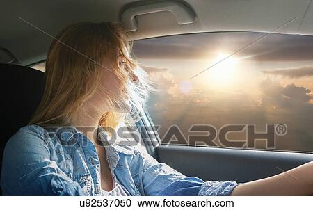 Woman driving car and watching sunset View Large Photo Image Stock Image - Woman driving car and watching sunset. Fotosearch