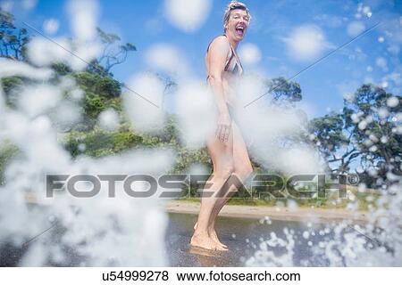 Woman excited at seawater splashing View Large Photo Image Stock Photo - Woman excited at seawater splashing. Fotosearch