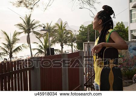 "Woman leaning on skateboard, Ipanema, Rio de Janeiro, Brazil" View Large Photo Image Picture - "Woman leaning on skateboard, Ipanema, Rio de Janeiro, Brazil". Fotosearch