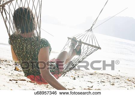 "Woman on beach hammock looking out to sea, Kradan, Thailand" View Large Photo Image Stock Photograph - "Woman on beach hammock looking out to sea, Kradan, Thailand". Fotosearch