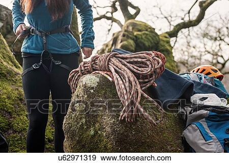 Stock Photo - Woman putting on climbing harness. Fotosearch