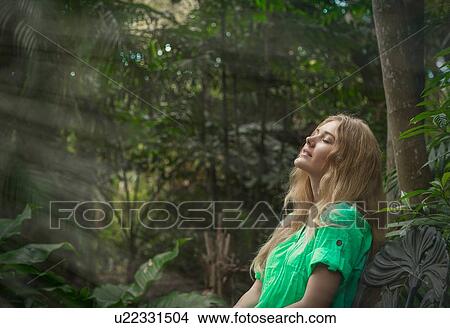 Picture - Woman relaxing in forest. Fotosearch