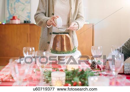 Stock Photo - Woman serving desert at family Christmas party. Fotosearch