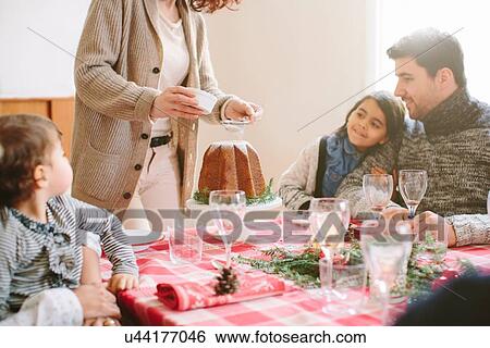 Woman serving desert at family Christmas party View Large Photo Image Stock Photograph - Woman serving desert at family Christmas party. Fotosearch