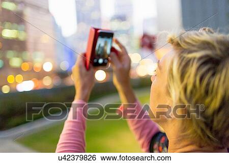 Woman taking photograph in Hong Kong View Large Photo Image Stock Photograph - Woman taking photograph in Hong Kong. Fotosearch