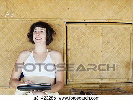 "Woman using digital tablet in front of beach hut, Kradan, Thailand" View Large Photo Image Stock Photography - "Woman using digital tablet in front of beach hut, Kradan, Thailand". Fotosearch