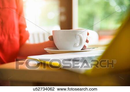 Stock Image - Woman using laptop at coffee break. Fotosearch