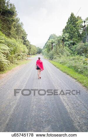 Woman walking away on straight road View Large Photo Image Stock Photo - Woman walking away on straight road. Fotosearch