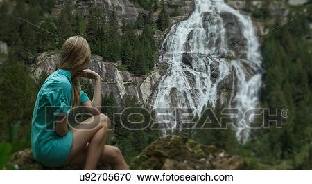 Stock Image - Woman watching waterfall. Fotosearch