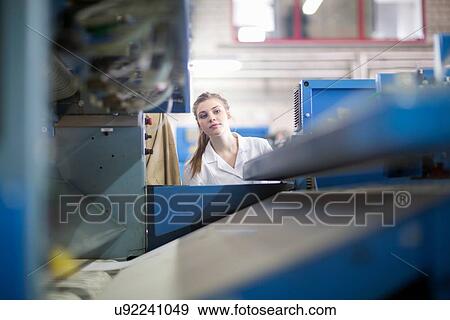 Stock Photo - Woman working at machinery in laundry. Fotosearch