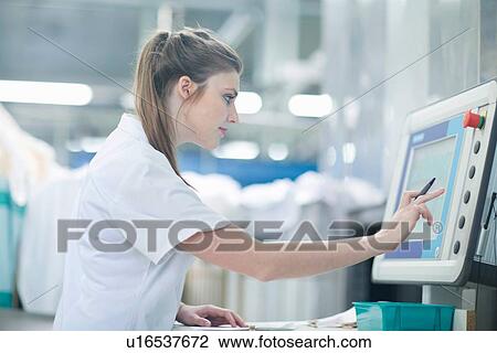 Woman working at monitor at laundry View Large Photo Image Stock Image - Woman working at monitor at laundry. Fotosearch