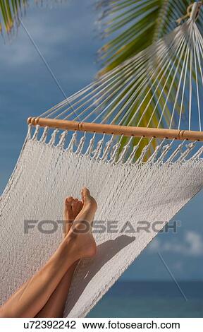 Stock Image - "Woman's feet lying in hammock, Ari Atoll, Maldives". Fotosearch