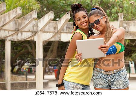 Stock Photo - "Women taking selfie using digital tablet, Rio de Janeiro, Brazil". Fotosearch