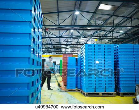 Worker arranging plastic crates in plastics factory View Large Photo Image Stock Image - Worker arranging plastic crates in plastics factory. Fotosearch