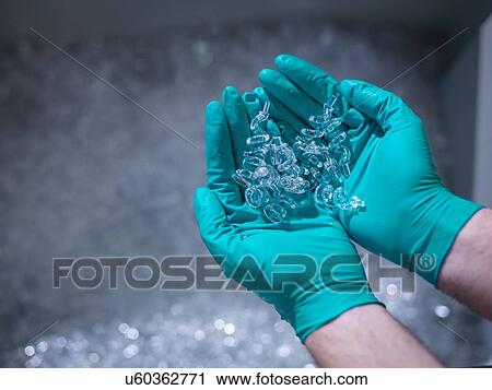 Stock Image - "Worker holding finished moulded plastic in plastics factory, close up". Fotosearch