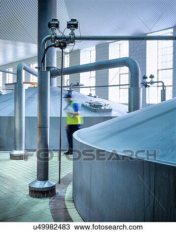 Worker in brewing hall of commercial brewery View Large Photo Image Stock Image - Worker in brewing hall of commercial brewery. Fotosearch