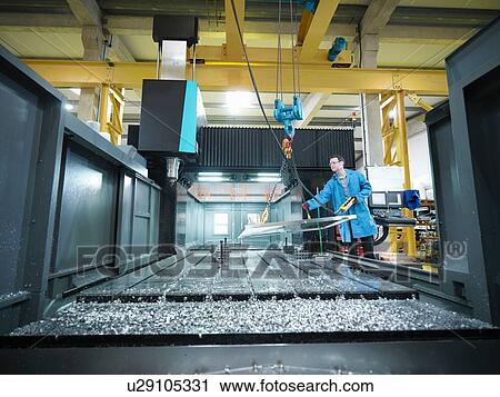 Worker in large CNC machine in plastics factory View Large Photo Image Stock Image - Worker in large CNC machine in plastics factory. Fotosearch
