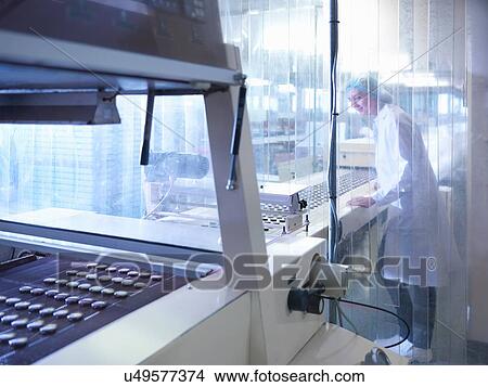 Picture - Worker inspecting chocolate on production line in chocolate factory. Fotosearch