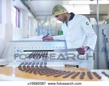 Worker inspecting chocolate on production line in chocolate factory View Large Photo Image Stock Photo - Worker inspecting chocolate on production line in chocolate factory. Fotosearch
