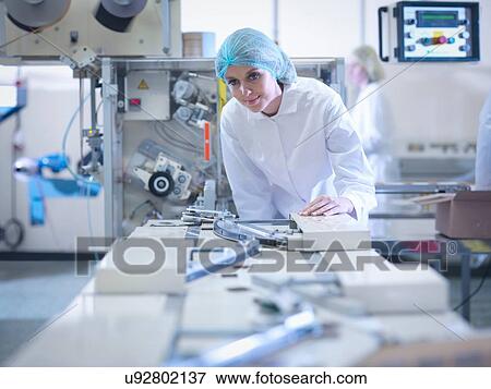 Stock Photo - Worker inspecting chocolate on production line in chocolate factory. Fotosearch