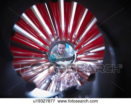 Stock Photo - Worker inspecting parts from plastic injection moulding machine in plastics factory. Fotosearch
