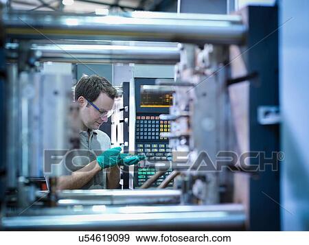 Stock Photo - Worker inspecting parts from plastic injection moulding machine in plastics factory. Fotosearch
