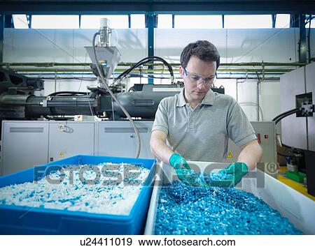 Worker inspecting recycled plastic in plastics factory View Large Photo Image Stock Photo - Worker inspecting recycled plastic in plastics factory. Fotosearch