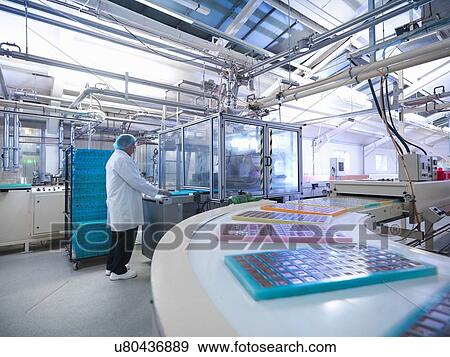 Stock Photo - Worker moulding chocolates in chocolate factory. Fotosearch
