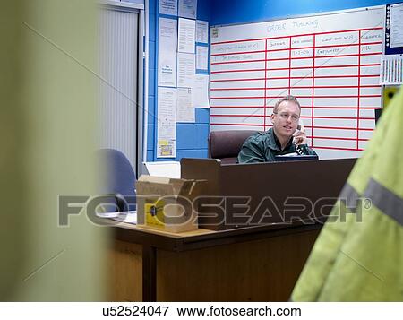 Worker on telephone in office in factory View Large Photo Image Stock Photo - Worker on telephone in office in factory. Fotosearch