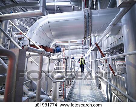 Worker on walkway in gas fired power station View Large Photo Image Picture - Worker on walkway in gas fired power station. Fotosearch