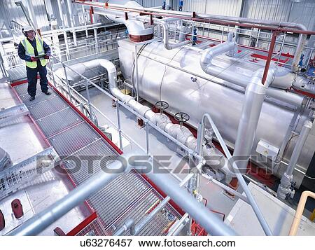 Worker on walkway in gas fired power station View Large Photo Image Stock Photo - Worker on walkway in gas fired power station. Fotosearch