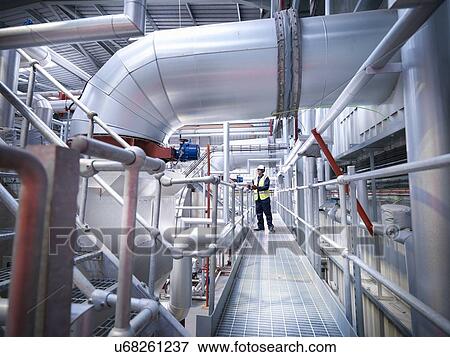 Stock Photo - Worker on walkway in gas fired power station. Fotosearch