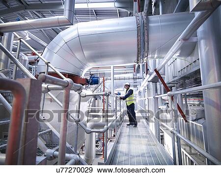 Worker on walkway in gas fired power station View Large Photo Image Stock Photo - Worker on walkway in gas fired power station. Fotosearch