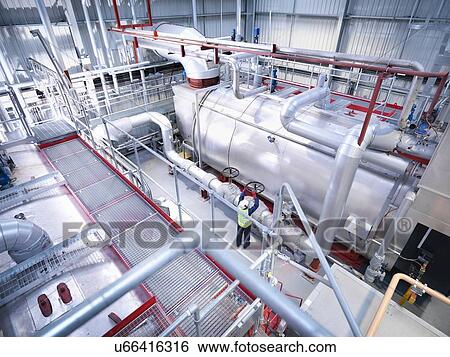 Worker on walkway in gas fired power station View Large Photo Image Stock Photograph - Worker on walkway in gas fired power station. Fotosearch