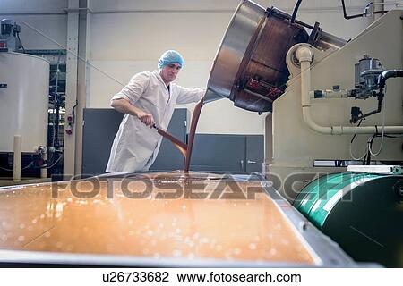 Worker pouring confectionery fudge in chocolate factory View Large Photo Image Stock Image - Worker pouring confectionery fudge in chocolate factory. Fotosearch