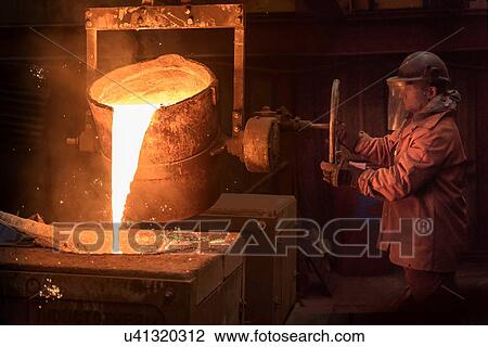Worker pouring molten metal from flask in foundry View Large Photo Image Stock Image - Worker pouring molten metal from flask in foundry. Fotosearch