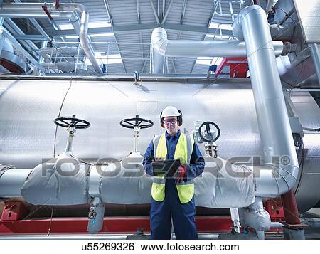 Worker using digital tablet in gas fired power station View Large Photo Image Stock Photograph - Worker using digital tablet in gas fired power station. Fotosearch