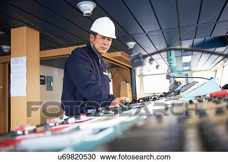 Stock Image - "Worker using equipment at shipping port, GoSeong-gun, South Korea". Fotosearch
