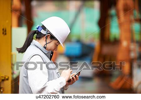 "Worker using smartphone at shipyard, GoSeong-gun, South Korea" View Large Photo Image Stock Image - "Worker using smartphone at shipyard, GoSeong-gun, South Korea". Fotosearch