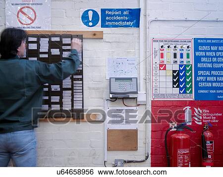 Worker using time clock in factory View Large Photo Image Stock Photograph - Worker using time clock in factory. Fotosearch