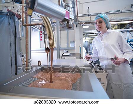 Worker watching chocolate being poured in chocolate factory View Large Photo Image Stock Image - Worker watching chocolate being poured in chocolate factory. Fotosearch