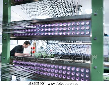 Stock Image - Worker weaving carbon fibre in carbon fibre factory. Fotosearch